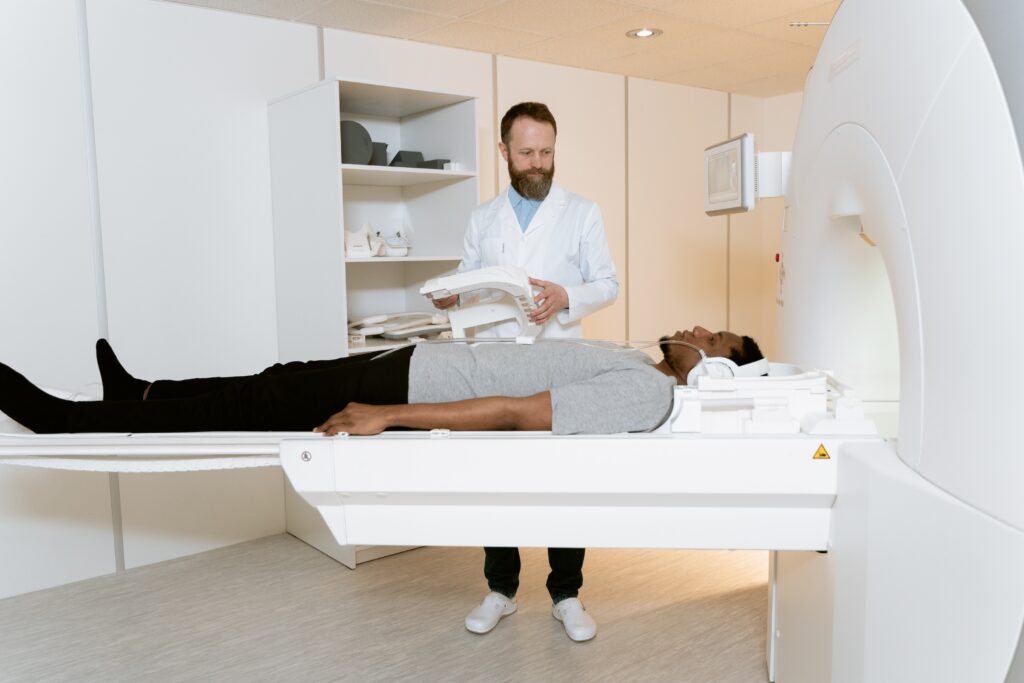Man is observed by doctor while entering MRI machine.