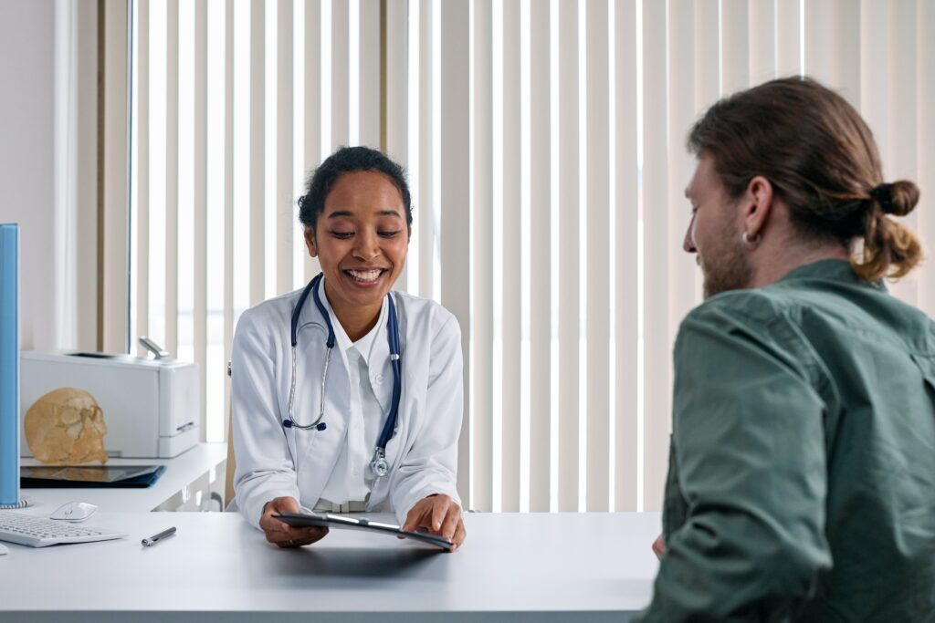 A doctor and patient talking over a medical sheet.